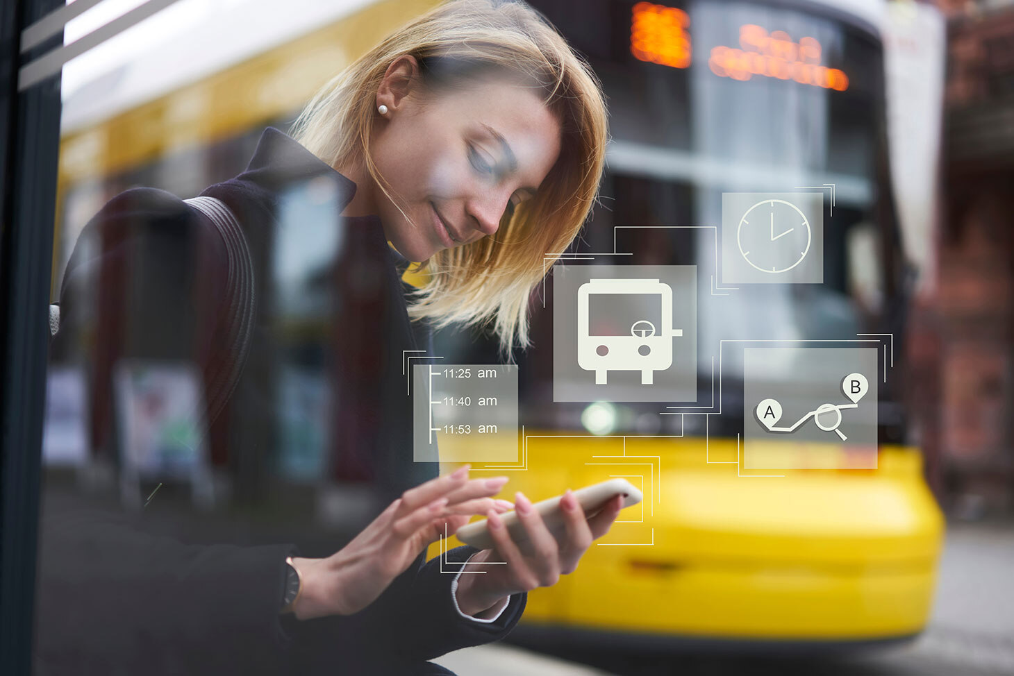 Eine junge Frau schaut auf ihr Smartphone, im Hintergrund eine Straßenbahn