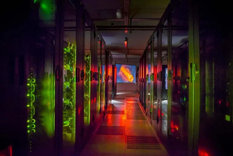 Blick in den grün ud rot beleuchteten Gang eines Rechenzentrums