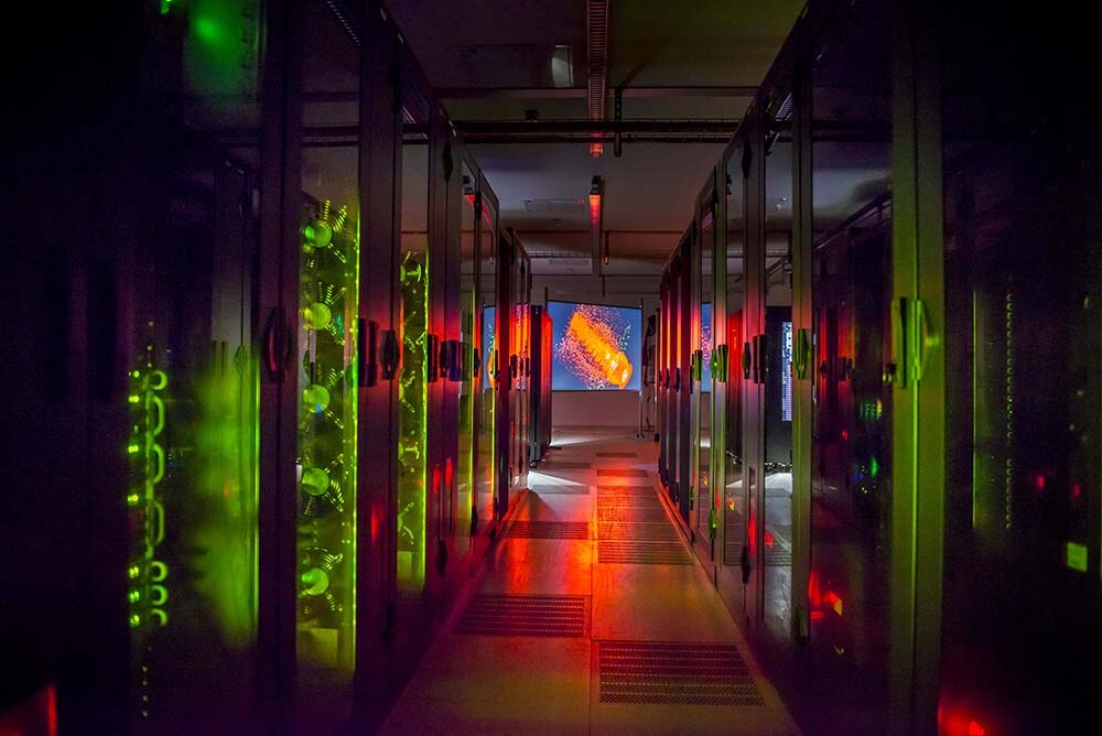 Blick in den grün ud rot beleuchteten Gang eines Rechenzentrums
